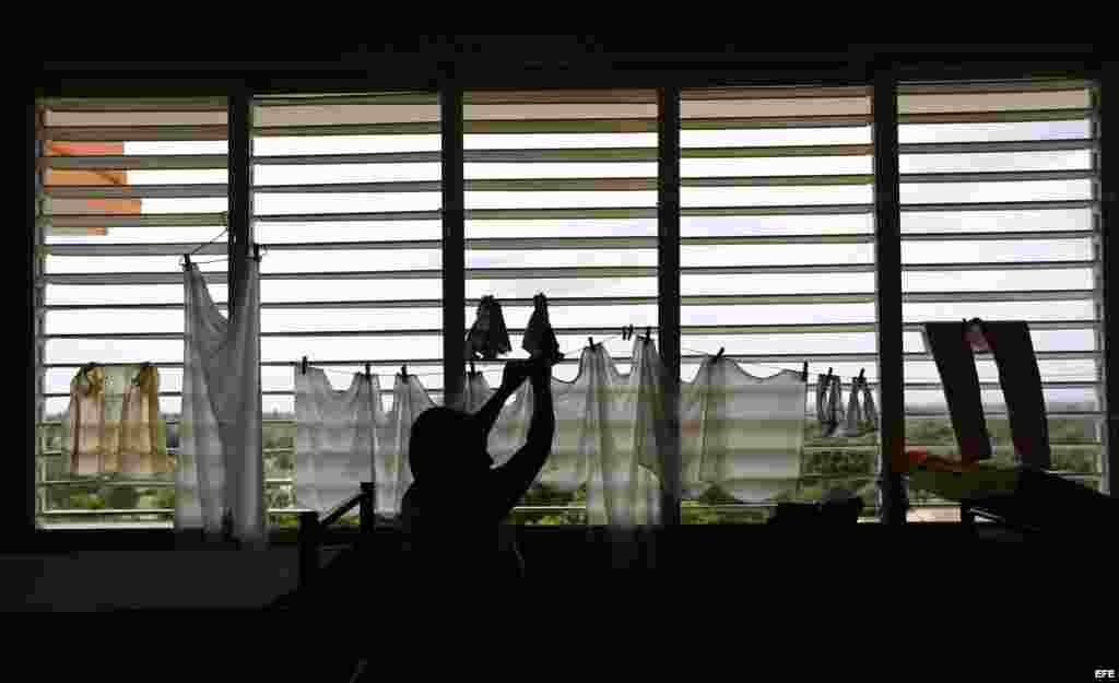  Una mujer cuelga ropa en un albergue hoy, lunes 03 de octubre de 2016, en la ciudad de Guantánamo (Cuba), ante la proximidad del huracán Matthew. Seis provincias de Cuba se encuentran bajo "alarma ciclónica" a la espera del potencial impacto del huracán 