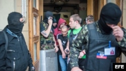 Fuerzas prorrusas enmascaradas resguardando el ingreso a una estación de TV regional en Donetsk