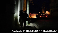 Varias personas caminan por una calle en pleno apagón en Cuba.