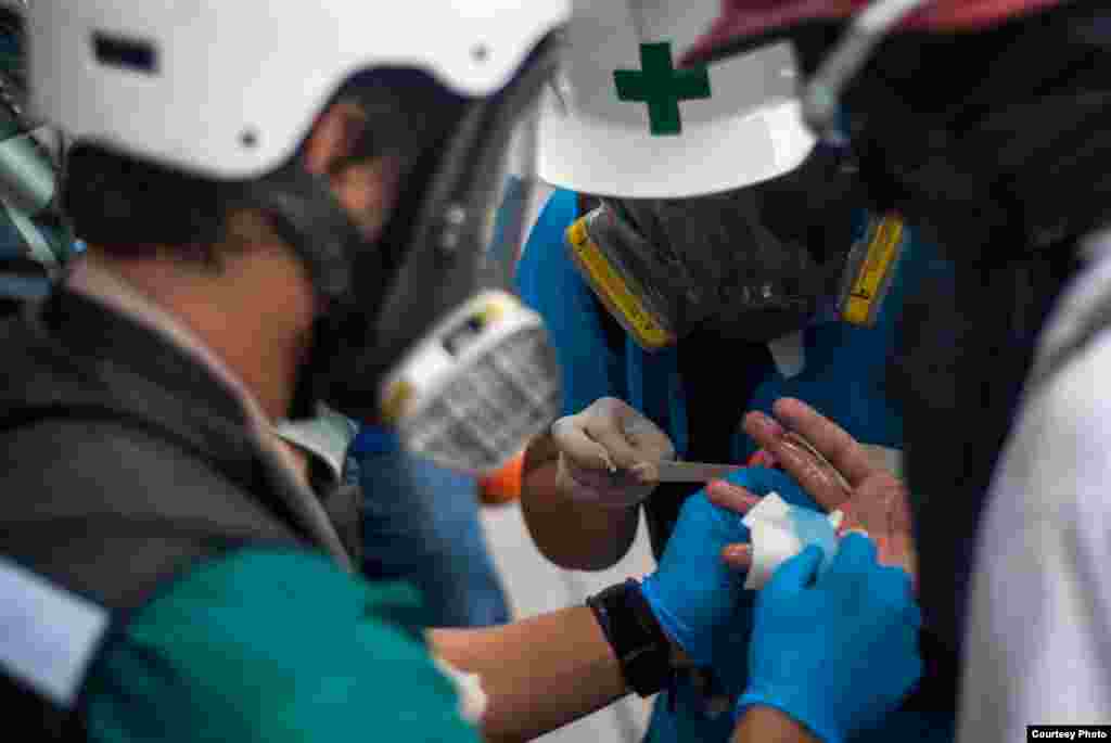 Grupo de Primeros Auxilios de la UCV, atienden a manifestante con una herida en la mano. (Foto: Juan Pablo Arraez) 