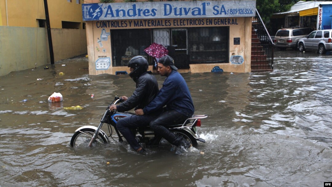 Un motociclista avanza por una calle inundada el miércoles 10 de junio de 2013, en Santo Domingo (República Dominicana).