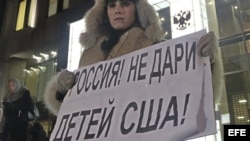Una mujer protesta en contra de la prohibición de adopción de huérfanos rusos a ciudadanos americanos a las puertas del Consejo de la Federación en Moscú (Rusia). 