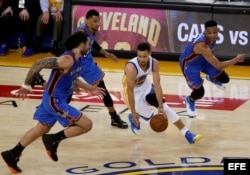 Stephen Curry (2-d) de Golden State Warriors avanza en medio de Steven Adams (i) y Russell Westbrook (d).