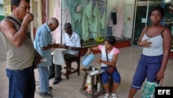  Varias personas toman café en el portal de una tienda, en La Habana, Cuba.