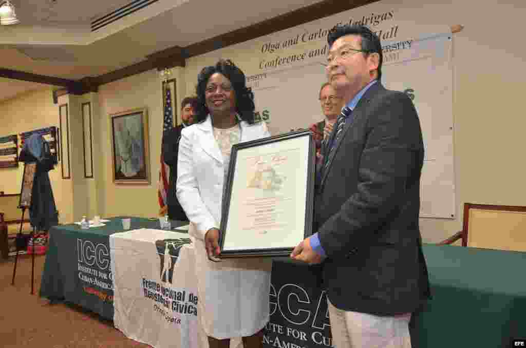 La disidente cubana Berta Soler (i) recibe el premio Pedro Luis Boitel en nombre de la fallecida Laura Pollán, de manos del disidente chino Yang Jianli, sobreviviente de la masacre de Tiananmen.
