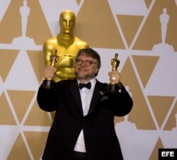Guillermo del Toro muestra sus dos estatuillas por mejor director y mejor película.