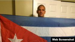 Osvaldo Ozzie Alonso Moreno, sostiene una bandera cubana.