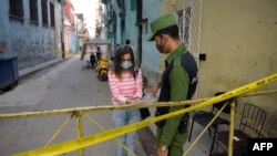 Un policía vigila la entrada a un barrio con brote de coronavirus en La Habana. (YAMIL LAGE / AFP)