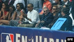 Barack Obama (c), su esposa, MIchelle Obama (3i, y sus hijas, Malia (i) y Sahsa (2i), y el mandatario cubano, Raúl Castro (3d), asisten al juego de béisbol entre el equipo de Cuba y los Rayos de Tampa Bay. 