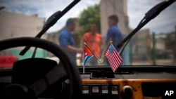 Imagen de banderas de EEUU y Cuba en un automóvil en La Habana, el 10 de agosto de 2016. (AP Photo/Ramón Espinosa).