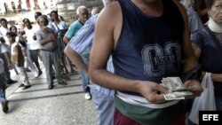 Un hombre cuenta los dólares que cambiará por pesos cubanos en una Casa de Cambio.