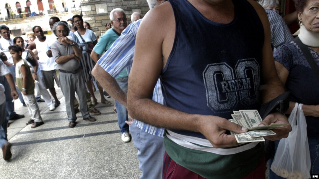 Un hombre cuenta los dólares que cambiará por pesos cubanos en una Casa de Cambio.