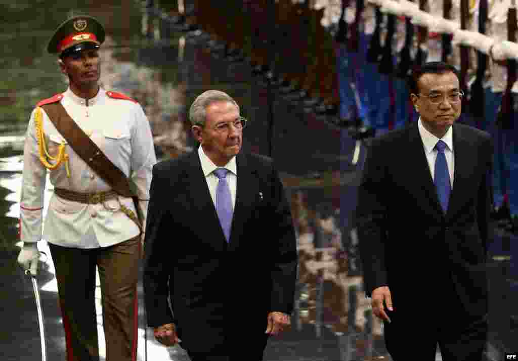 Raúl Castro (c), y el primer ministro de China, Li Keqiang pasan revista a las tropas formadas para la ceremonia oficial de recibimiento en el Palacio de la Revolución de La Habana.