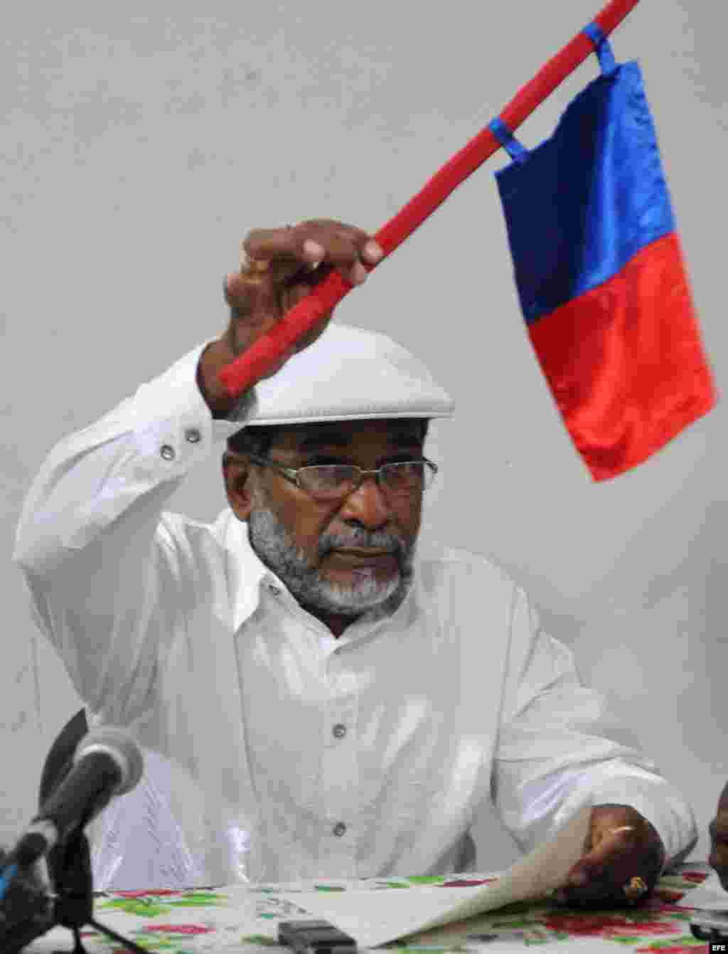El sacerdote de Ifá o "babalawo" cubano Lázaro Cuesta muestra la bandera del signo regente del año 2014.