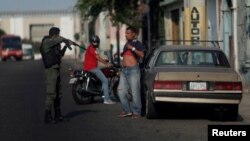 Un guardia apunta con un fusil a un venezolano en Maracaibo.