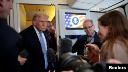 El presidente de los Estados Unidos, Donald Trump, habla con miembros de los medios de comunicación a bordo del Air Force One, tras su visita a China.