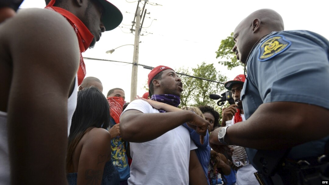 El capitán Ron Johnson (dcha), de la policía de Misuri, escucha las protestas de los manifestantes sobre la muerte del joven Michael Brown en Ferguson, Misuri, (Estados Unidos).