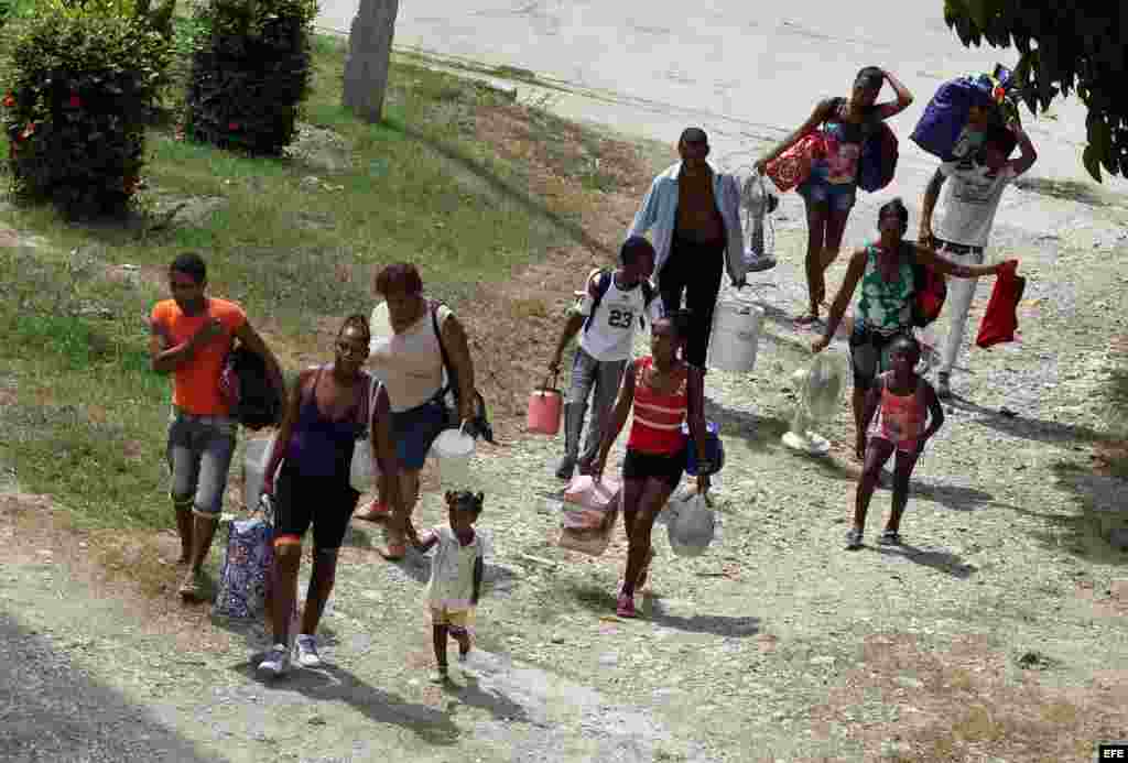 Varias personas evacuadas arriban a una escuela convertida en albergue hoy, lunes 03 de octubre de 2016, en la ciudad de Guantánamo (Cuba), ante la proximidad del huracán Matthew. Seis provincias de Cuba se encuentran bajo "alarma ciclónica" a la espera d