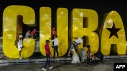 FOTO ARCHIVO. Niños juegan en una gran cartel de Cuba, en un espacio público de la ciudad de Santiago de Cuba. Foto ADALBERTO ROQUE / AFP
