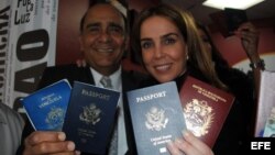 La periodista venezolana Lourdes Ubieta, acompañada de Carlos Herrades, muestran sus dos pasaportes, de Venezuela y Estados Unidos. 