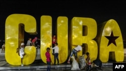 Niños juegan en un gran cartel en el malecón en Santiago de Cuba en septiembre del 2018. (Adalberto Roque / AFP).