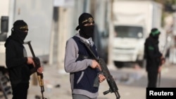 Milicianos de Hamás y de la Yihad Islámica Palestina permanecen de pie en una calle durante el Eid al-Fitr en la ciudad de Gaza, el 20 de marzo de 2026. REUTERS/Dawoud Abu Alkas