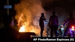 Un policía intenta apagar un incendio provocado durante una protesta ciudadana en  La Habana, Cuba, el 14 de mayo de 2026. Cubalex documentó 106 protestas populares en mayo. (Foto AP/Ramon Espinosa)