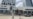 Una mujer toma una fotografía mientras camina frente al hotel donde unos trabajadores retiran de la fachada el nombre de la marca "Aston" —perteneciente a la cadena hotelera Archipelago International.
