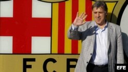 El nuevo entrenador del F.C.Barcelona, el argentino Gerardo 'Tata' Martino, posa ante el escudo barcelonista.