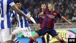 Delantero mexicano de la Real Sociedad Carlos Vela (i) lucha un balón con Andrés Iniesta.