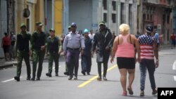 Policías y guardias caminan por una calle de La Habana.