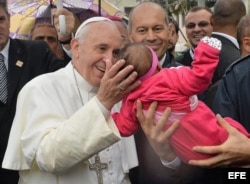El papa Francisco (i) bendice a un bebé durante su visita a la favela Varginha, en Río de Janeiro, Brasil, hoy, jueves 25 de julio de 2013.
