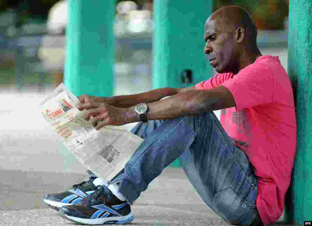 Un hombre lee el periódico Granma. 