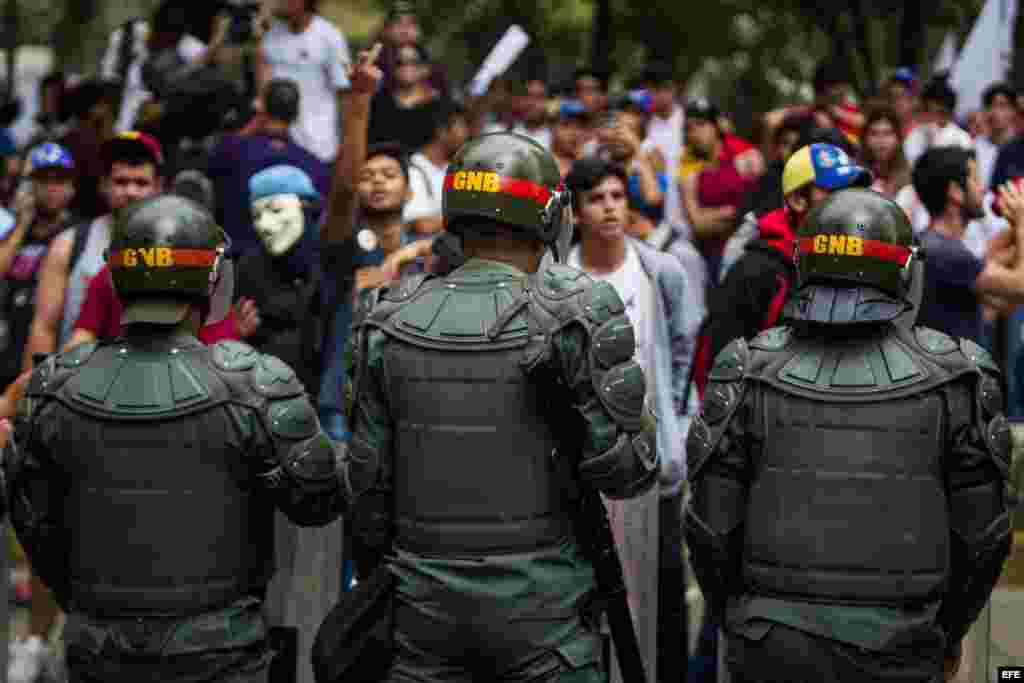 Miembros de la Guardia Nacional Bolivariana (GNB) vigilan mientras opositores se movilizan hoy, jueves 12 de febrero de 2015, en recuerdo de los fallecidos hace un año al término de una manifestación de la oposición, lo que dio inicio a un ola de protesta