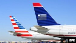 Fotografía fechada el 14 de febrero de 2013 que muestra un avión de la compañía US Airways (d) junto a uno de la compañía American Airlines (i), en el aeropuerto internacional de Ft. Worth (Texas), EE.UU.