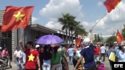 Vietnamitas con banderas nacionales junto a una fábrica de propiedad china en la localidad de Binh Duong, Vietnam.
