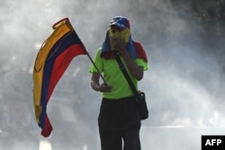 Un opositor sostiene una bandera venezolana durante las manifestaciones en Caracas contra Nicolás Maduro.