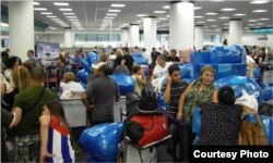 Los cubanos que viajan a Cuba en el aeropuerto de Miami se identifican por su abundante equipaje.