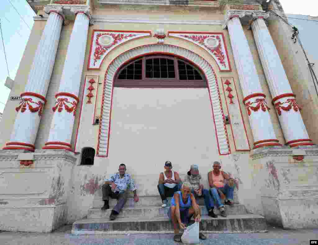 Varios ancianos conversan en la puerta de un antiguo teatro en el poblado de Regla, en La Habana. Foto Archivo. La población cubana es la más longeva de América, con un 18&nbsp;% de los habitantes en la tercera edad.