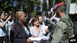 Opositores venezolanos entregan copias de la Ley de Amnistía a militares y policías al servicio del régimen de Nicolás Maduro. 