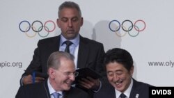 l presidente del COI, el belga Jacques Rogge (d), y el primer ministro de Japón, Shinzo Abe, participan en una rueda de prensa. 