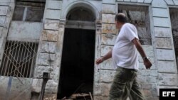  Un hombre camina frente a un edificio que se derrumbó parcialmente debido a las fuertes lluvias y que se encuentra ubicado en el barrio de Centro Habana, en La Habana (Cuba). 