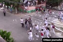 Damas de Blanco lanzan octavillas antes de ser detenidas por la policía.