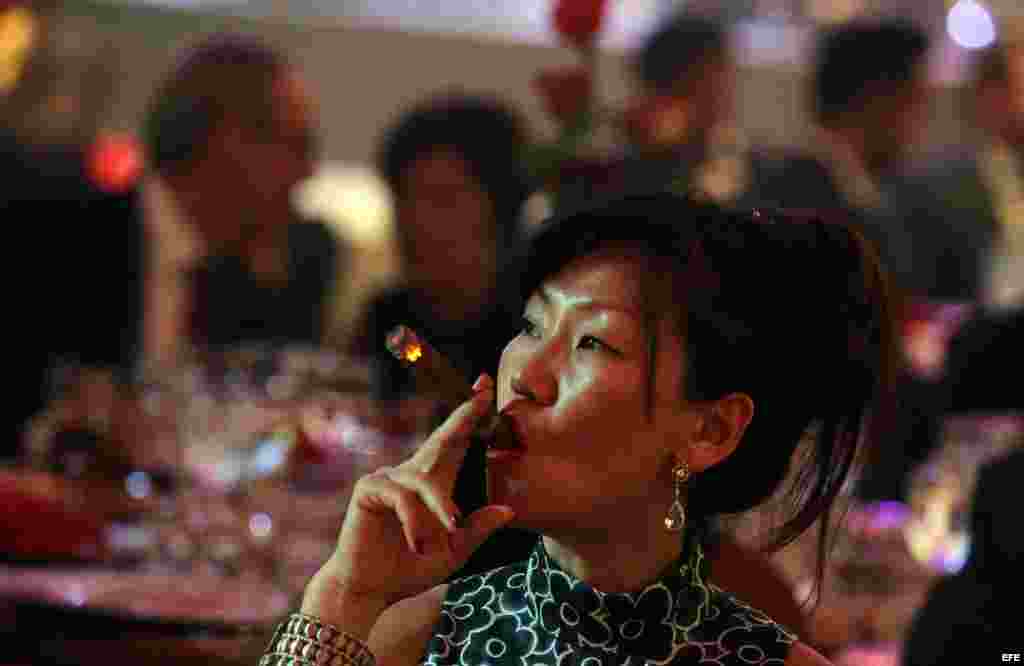 Una mujer fuma durante la gala que cerró el XVII Festival Internacional del Habano