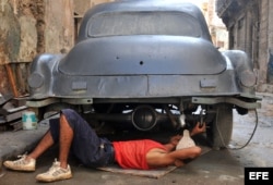 Un hombre trabaja en la reparación de un auto.