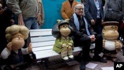 Joaquín Salvador Lavado, más conocido como "Quino", posa con estatuas de personajes que creó para su tira de "Mafalda".