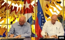 El vicepresidente de Venezuela Rafael Ramírez (i), y el ministro cubano para el Comercio Exterior y la Inversión Extranjera, Rodrigo Malmierca (d), firman un acuerdo de cooperación.