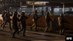 Miembros de la Guardia Nacional Bolivariana (GNB) permanecen alerta hoy, lunes 17 de febrero de 2014, durante protestas registradas en el sector Los Ruices, cerca al canal de televisión estatal "Venezolana de Televisión" (VTV), en Caracas (Venezuela).
