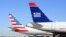 Fotografía fechada el 14 de febrero de 2013 que muestra un avión de la compañía US Airways (d) junto a uno de la compañía American Airlines (i), en el aeropuerto internacional de Ft. Worth (Texas), EE.UU.