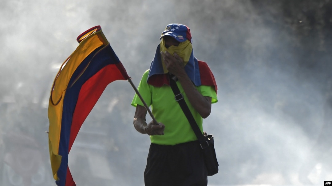 Un opositor sostiene una bandera venezolana durante las manifestaciones en Caracas contra Nicolás Maduro. 